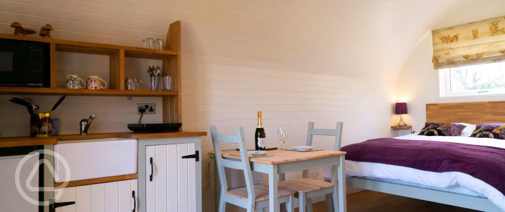 Four person pod kitchen area with a microwave, induction hob, and utensils