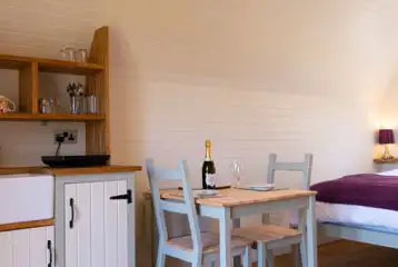 Four person pod kitchen area with a microwave, induction hob, and utensils Four person pod kitchen area with a microwave, induction hob, and utensils