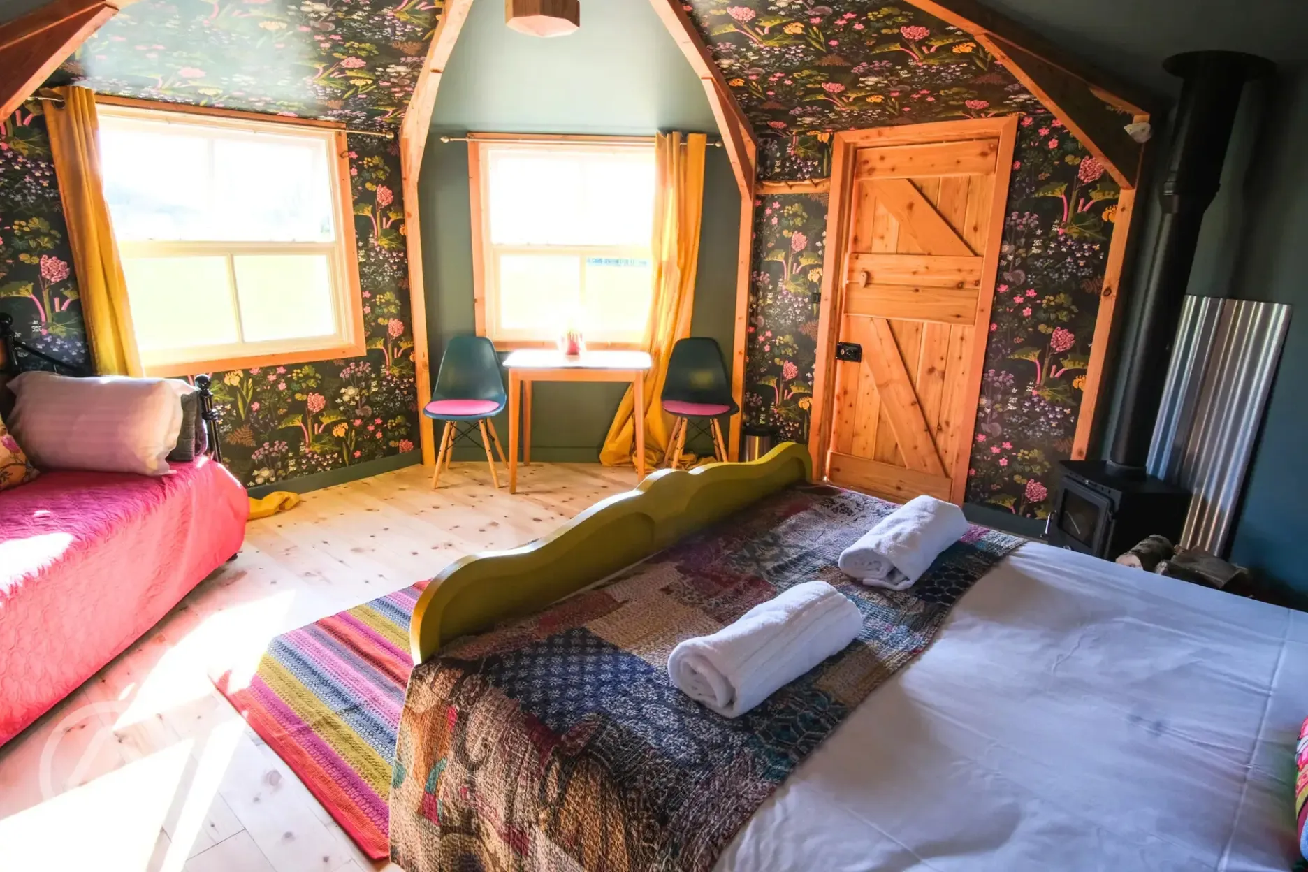 Glamping cabin interior with a day bed and desk area