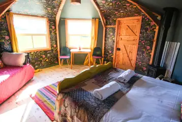 Glamping cabin interior with a day bed and desk area