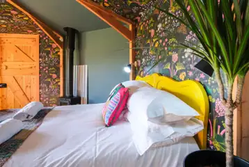 Glamping cabin with a double bed and soft furnishings