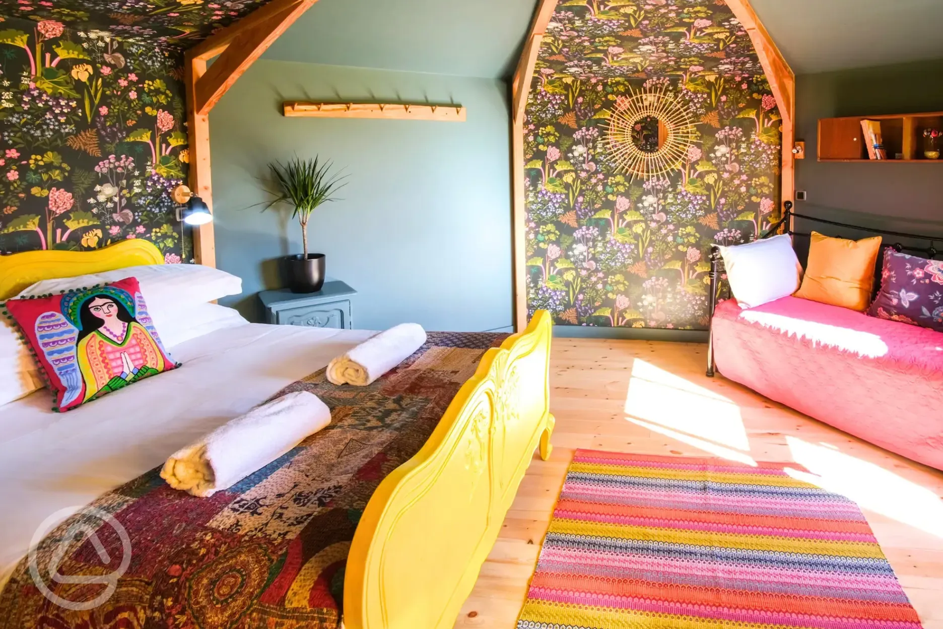 Glamping cabin interior with a double bed, two single beds and wood burner