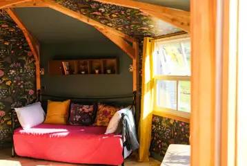 Glamping cabin interior with a day bed that converts to two singles