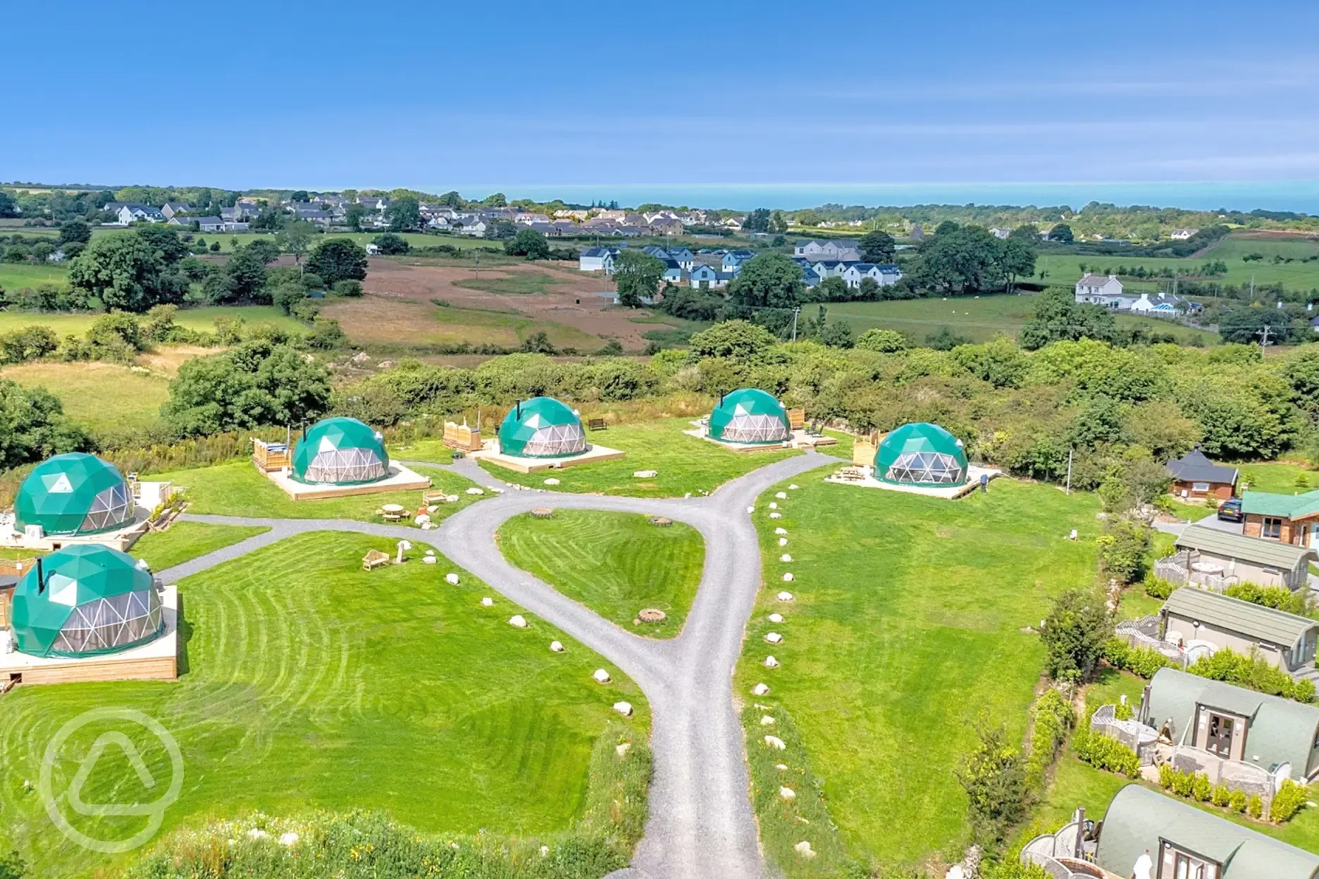 Aerial of Brynteg Glamping with the coast in the background