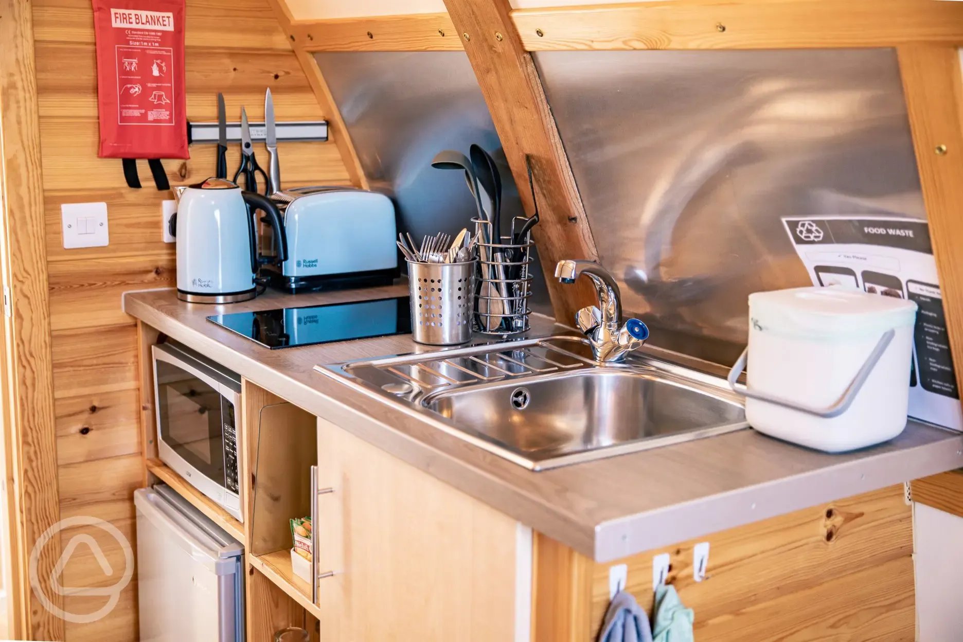 Glamping pod equipped kitchen with a microwave, fridge, toaster, kettle and sink
