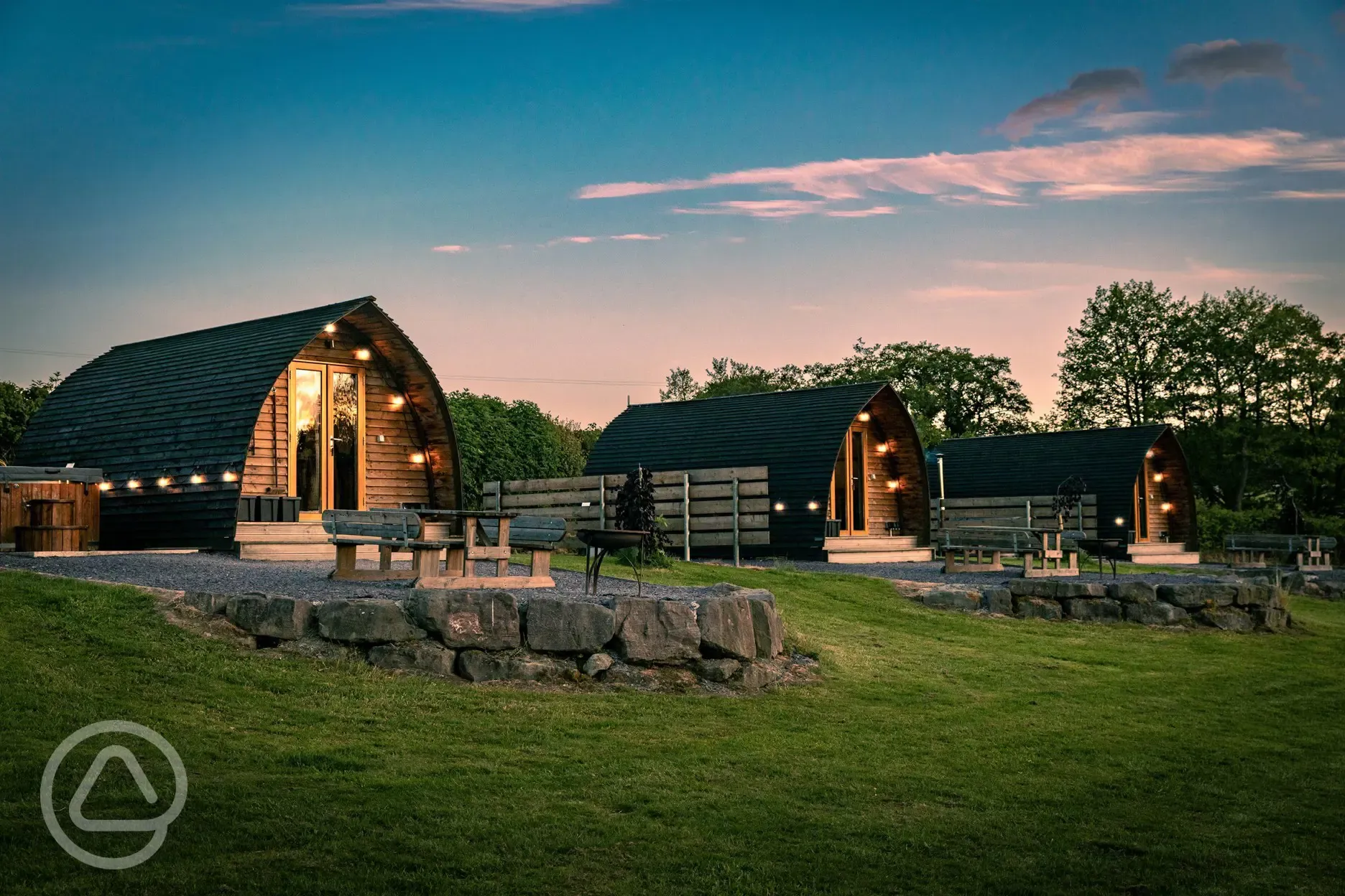 Glamping pods at dusk with outdoor lighting