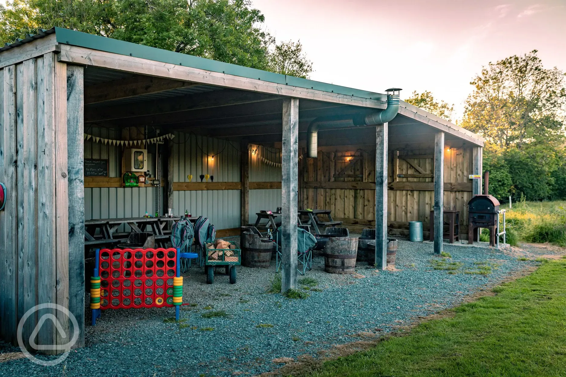 Communal sheltered area with seating, games and a pizza oven