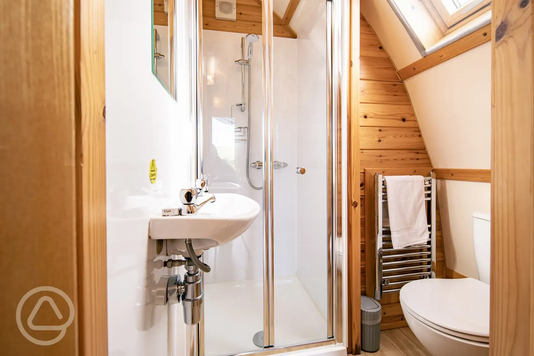 Glamping pod ensuite bathroom with a toilet, shower, sink and towel rail