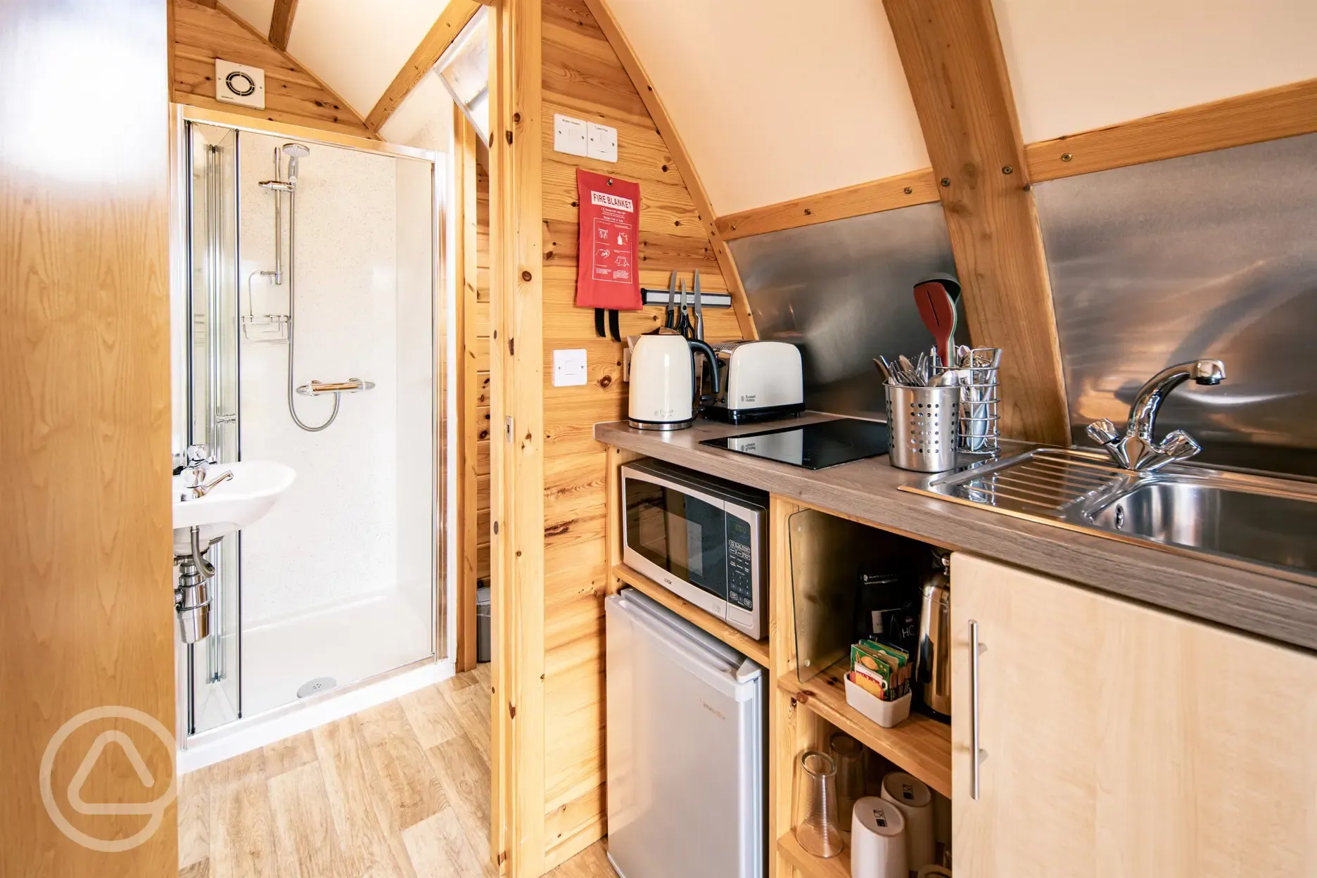 Glamping pod equipped kitchen and door to the ensuite bathroom
