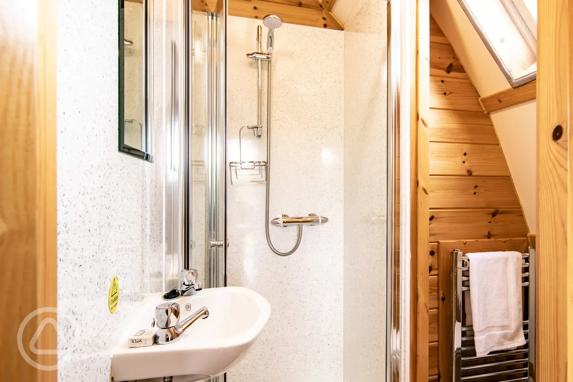 Glamping pod ensuite bathroom with a toilet, shower, sink and towel rail