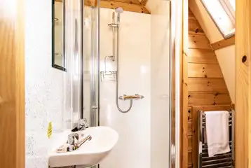 Glamping pod ensuite bathroom with a toilet, shower, sink and towel rail