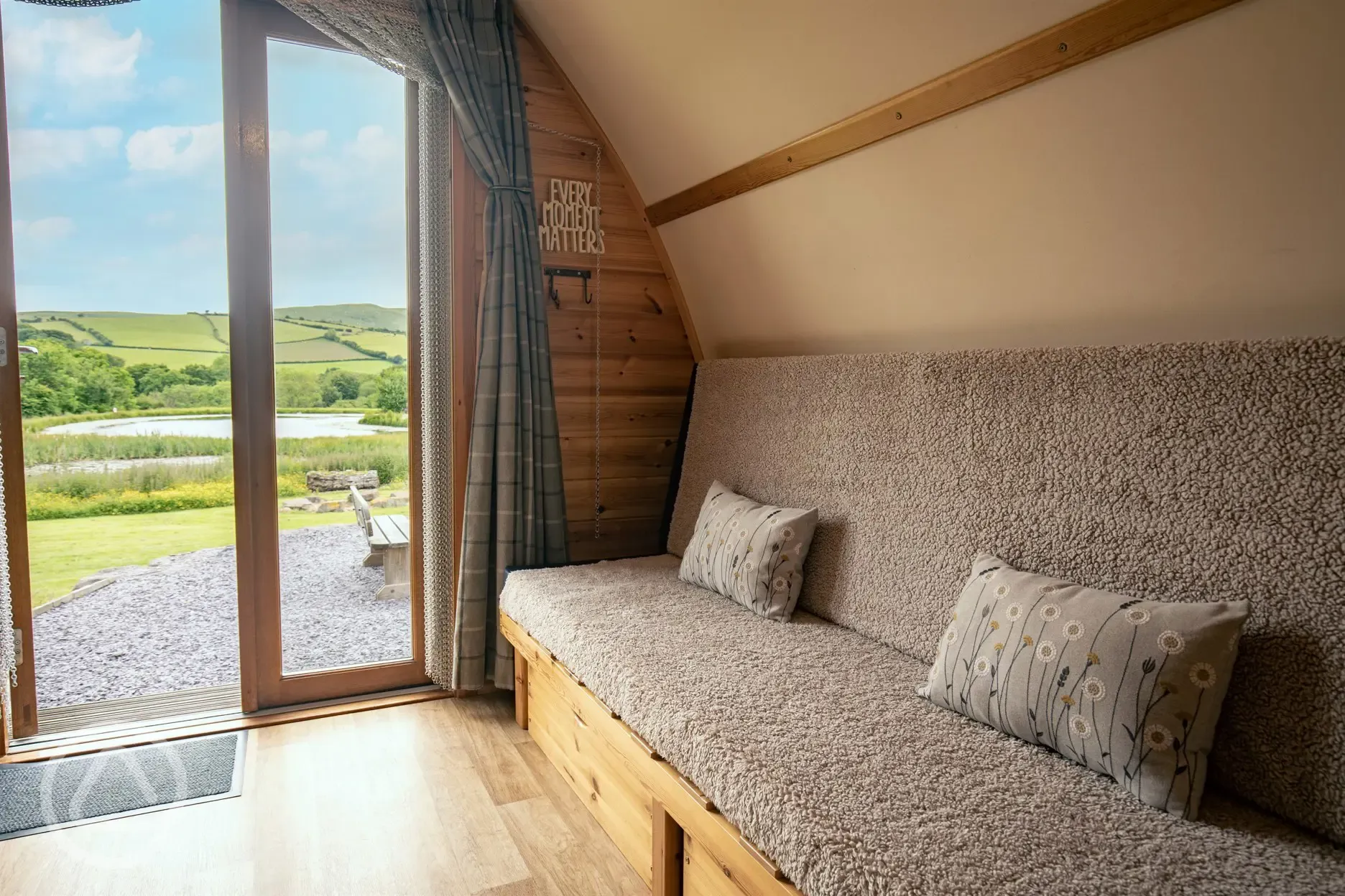 Glamping pod sofa bed with views of the lake and countryside