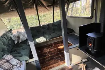 Saltings Landpod interior with cushioned bunches and a log burner