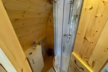 Glamping pod ensuite with a toilet, hot shower, and handwashing sink