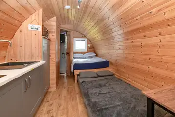 Four person glamping pod interior with a double bed and sofa bed Four person glamping pod interior with a double bed and sofa bed