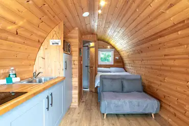 Four person glamping pod interior with a double bed and sofa bed