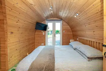 Llys y Llwynogod double bedroom with glass doors and TV Llys y Llwynogod double bedroom with glass doors and TV