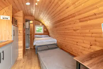 Four person glamping pod interior with a double bed and sofa bed Four person glamping pod interior with a double bed and sofa bed