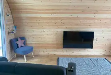 Llys y Llwynogod pod interior with a smart TV, a speaker, and WiFi