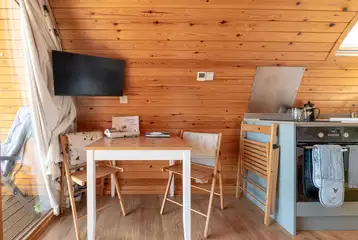 Ensuite glamping pod dining space with a wall mounted TV Ensuite glamping pod dining space with a wall mounted TV