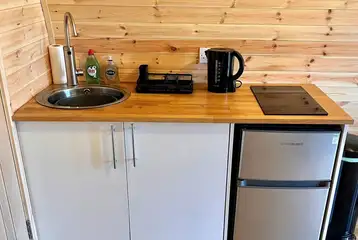 Luxury pod kitchen with a hob, kettle, microwave, fridge/freezer and sink