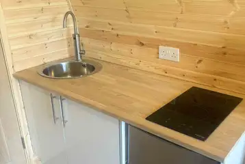 Luxury pod kitchen with a hob, kettle, microwave, fridge/freezer and sink