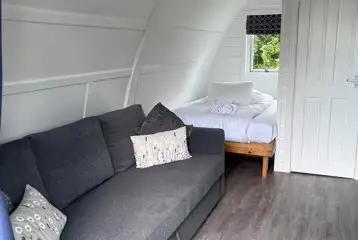 Adult only ensuite glamping pod interior with bed and sofa - pet free