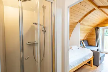 Glamping pod ensuite with shower and view of the bed