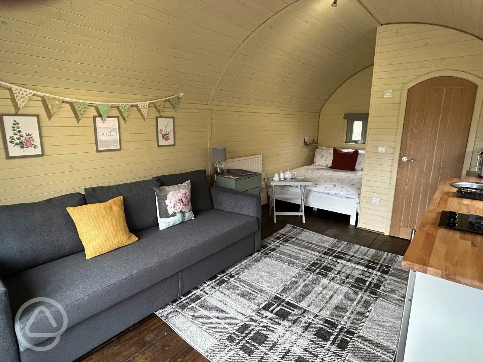 Glamping pod with hot tub interior with double bed and sofa