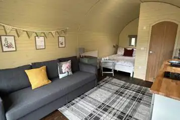 Glamping pod with hot tub interior with double bed and sofa Glamping pod with hot tub interior with double bed and sofa