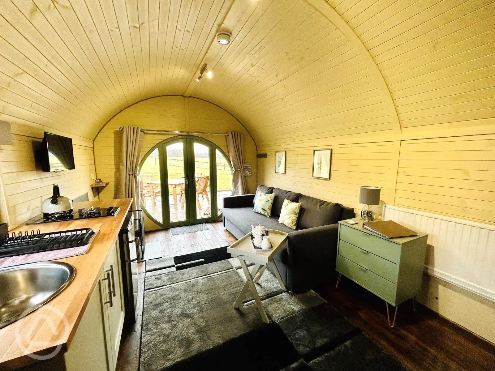 Family glamping pod with hot tub interior with seating area and kitchenette