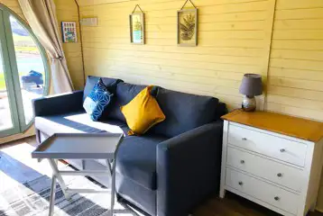 Family glamping pod interior with sofa Family glamping pod interior with sofa