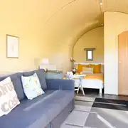 Glamping pod interior with double bed, sofa and ensuite Glamping pod interior with double bed, sofa and ensuite