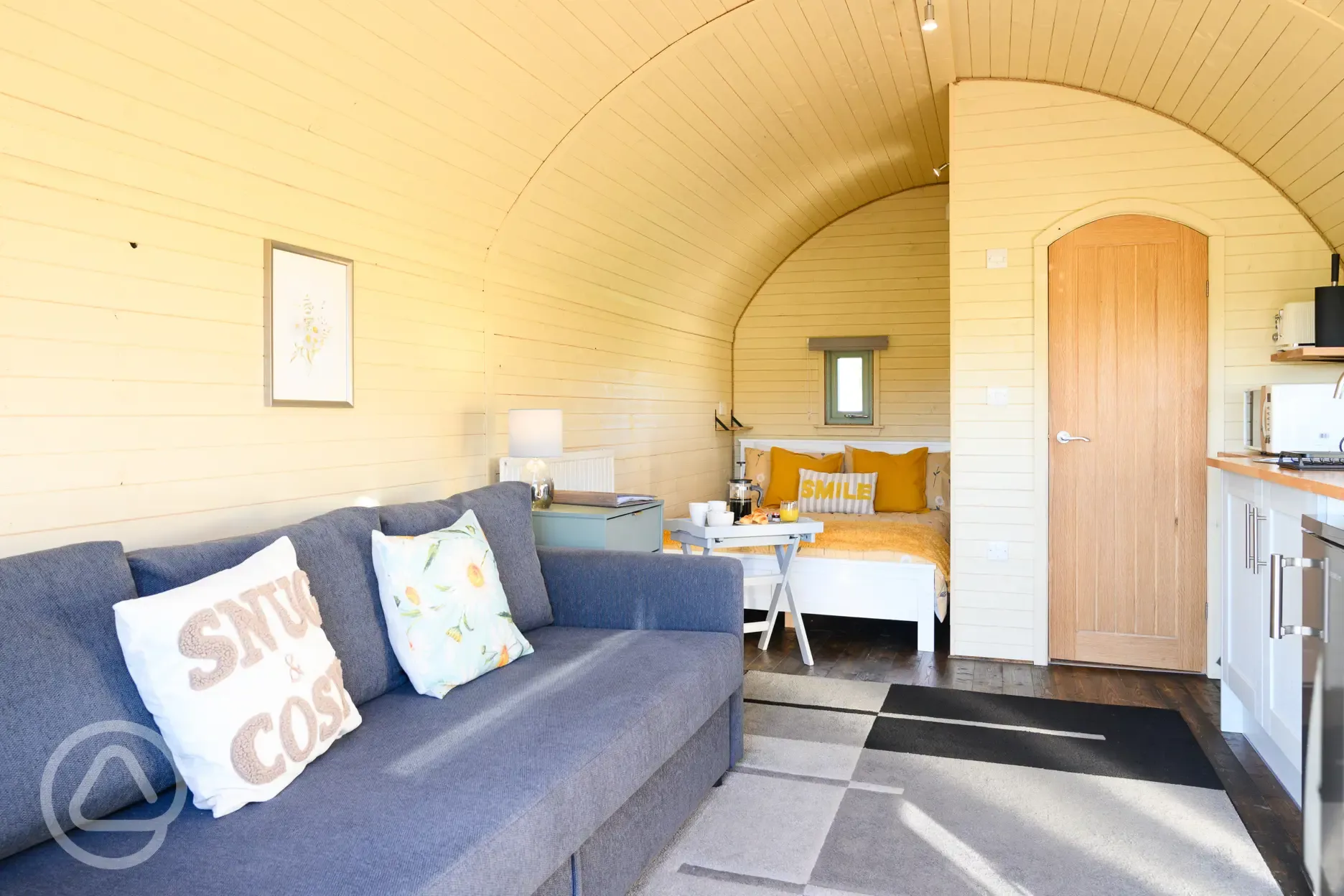 Glamping pod interior with double bed, sofa and ensuite
