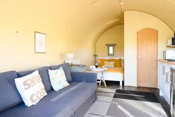 Glamping pod interior with double bed, sofa and ensuite Glamping pod interior with double bed, sofa and ensuite