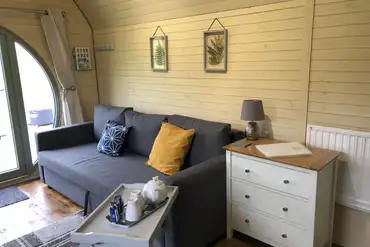 Standard glamping pod interior with sofa bed