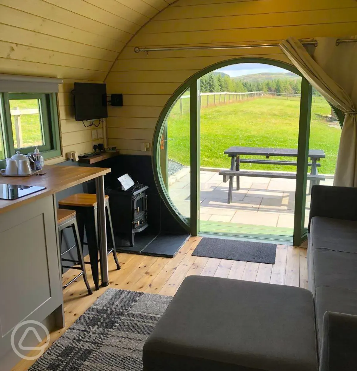 Adult only glamping pod interior with seating, log burner and countryside views