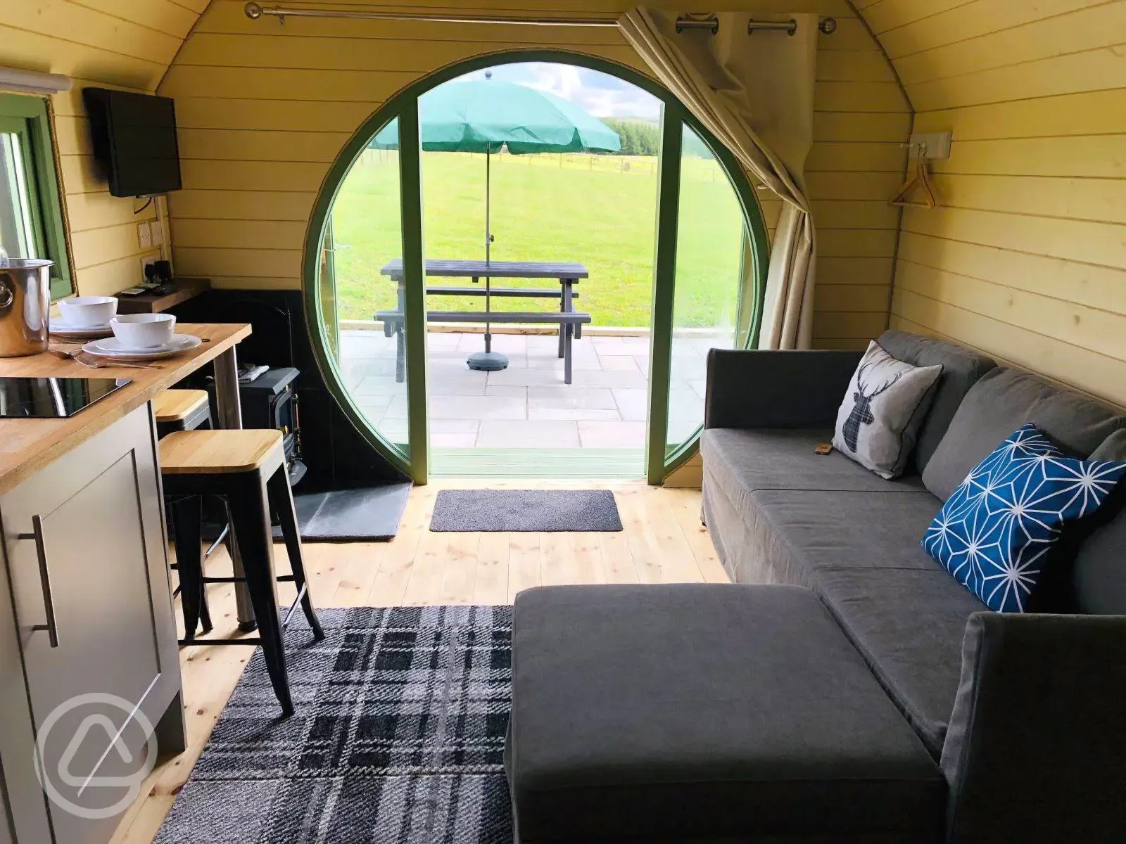 Standard glamping pod interior with sofa bed, seating and countryside views