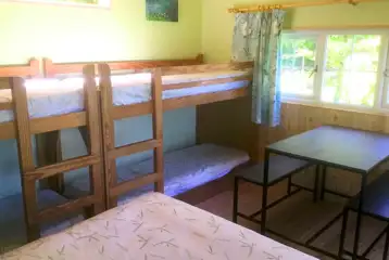 Primrose cabin with a double bed, two bunk beds, a table and chairs Primrose cabin with a double bed, two bunk beds, a table and chairs
