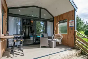 Stargazer glamping cabin decking with a table, chairs and swing seat Stargazer glamping cabin decking with a table, chairs and swing seat