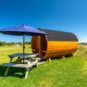 Barrel camping pod with a picnic bench and umbrella Barrel camping pod with a picnic bench and umbrella