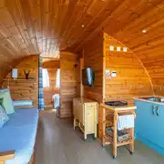 Glamping pod with a sofa, TV and kitchen