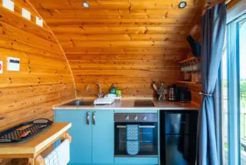 Glamping pod kitchen with an oven, hob, fridge/freezer and more