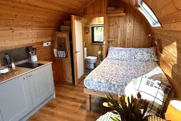 Bracken glamping pod interior with a double bed, kitchen and ensuite