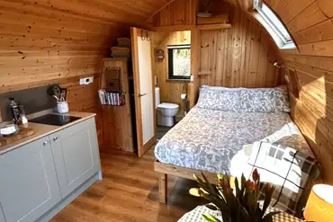Bracken glamping pod interior with a double bed, kitchen and ensuite