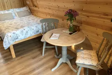 Bracken pod interior with a double bed, table and chairs