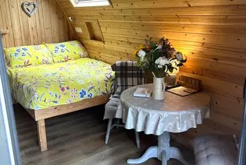 Bracken pod interior with a double bed, table and chairs