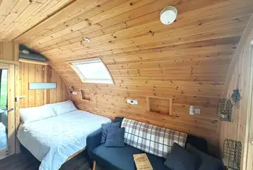 Willow glamping pod interior with a double bed and sofa bed