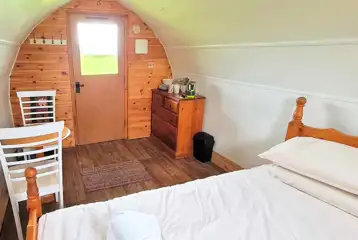 Camping pod interior with a double bed and seating