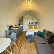Luxury ensuite glamping pod with a double bed, dining space, sofa, and kitchen Luxury ensuite glamping pod with a double bed, dining space, sofa, and kitchen